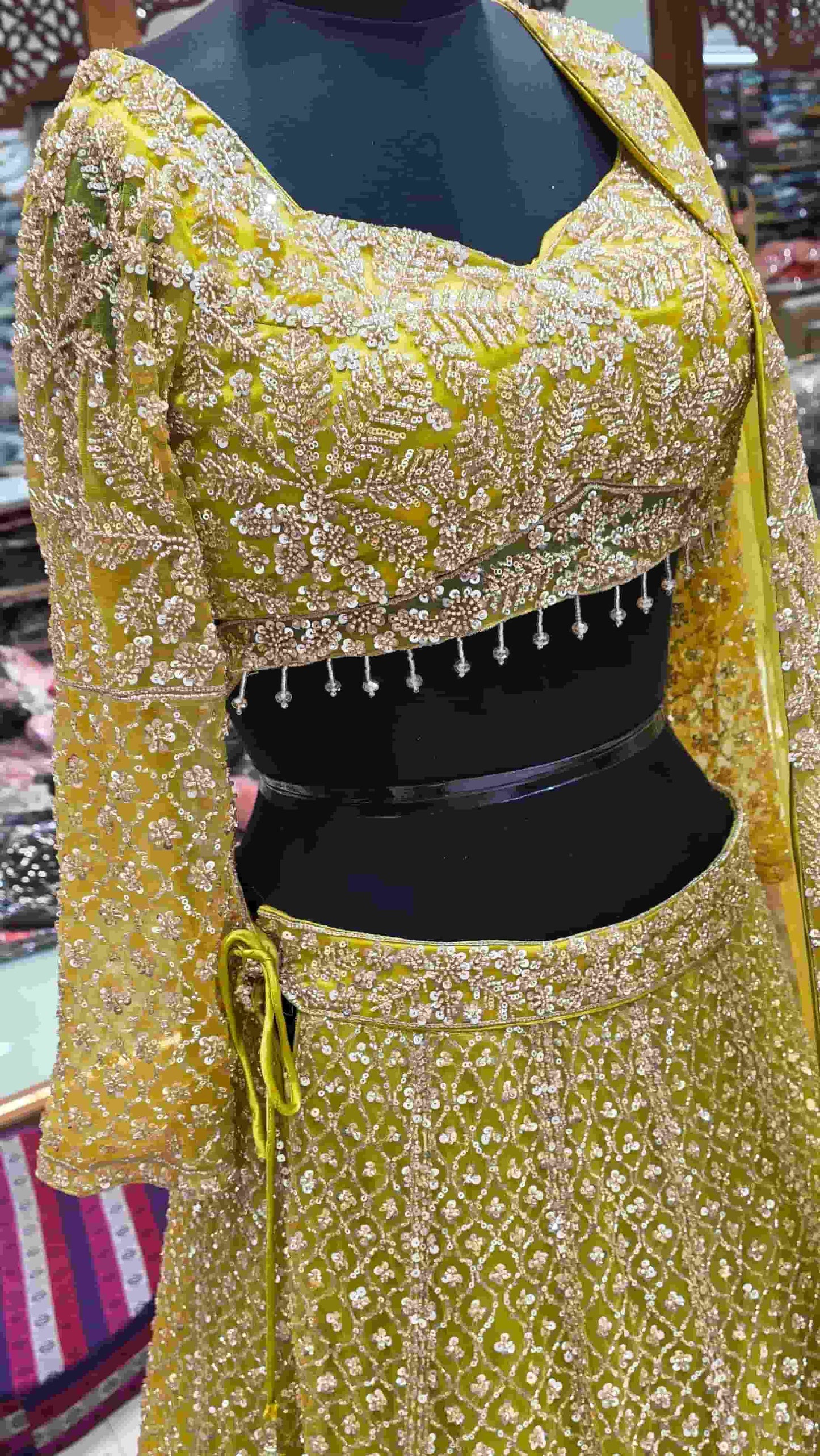Mustard yellow embroidered lehenga set with heavy sequin work and net dupatta front view.