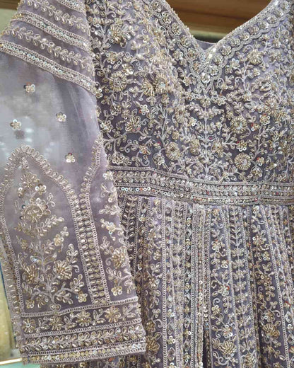 Close-up of V-neck bodice on dusty lavender embroidered Anarkali with intricate bead and zari detailing.