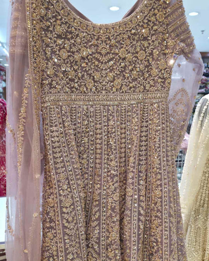 Flared hemline and front slit detail of dusty lavender embroidered Anarkali gown with vertical panel work.