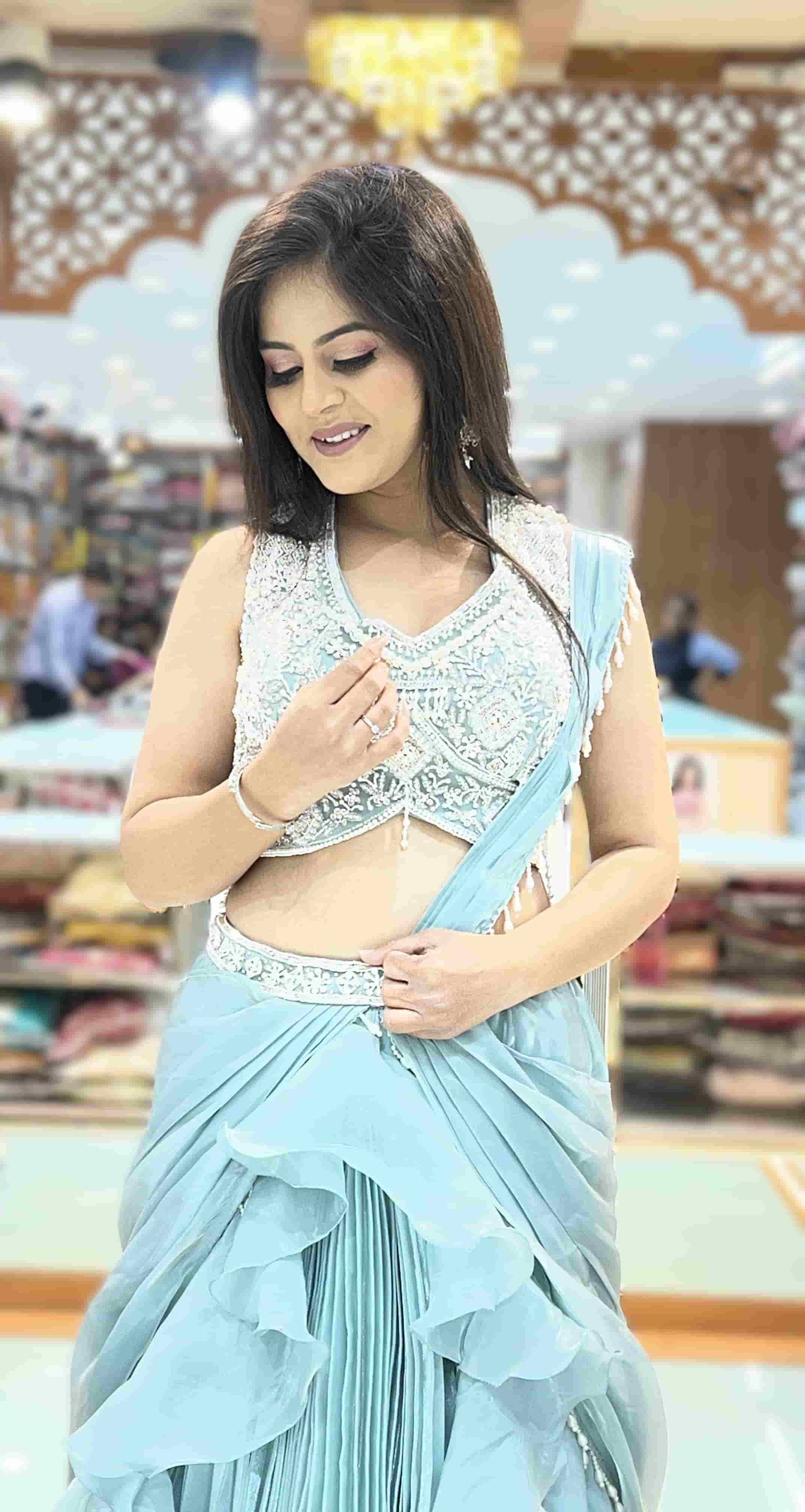 Pastel blue designer Indo-Western lehenga featuring layered ruffles and embroidered V-neck blouse.