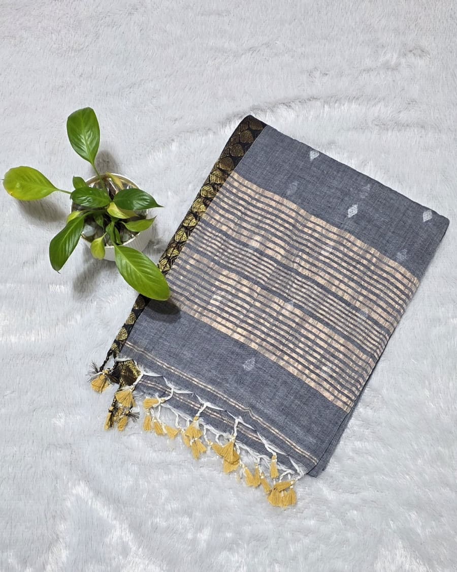 Gray pure cotton saree with all over silver butti work, golden line stripes at the pallu and golden border ideal for alll day and office work