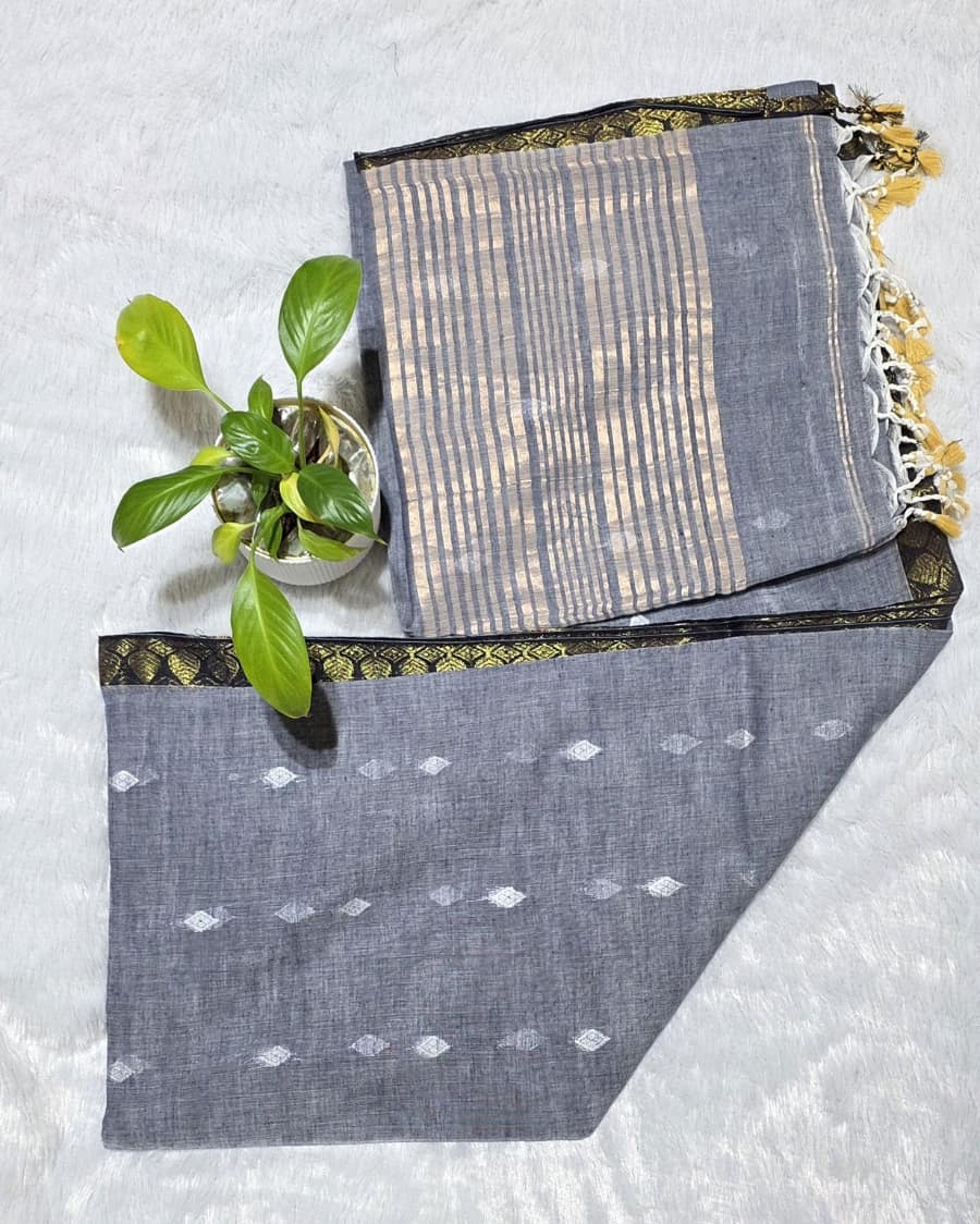 Gray pure cotton saree with all over silver butti work, golden line stripes at the pallu and golden border ideal for alll day and office work