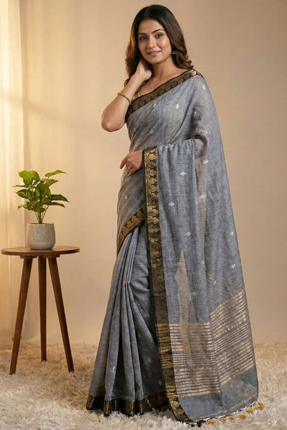 Gray pure cotton saree with all over silver butti work, golden line stripes at the pallu and golden border ideal for alll day and office work
