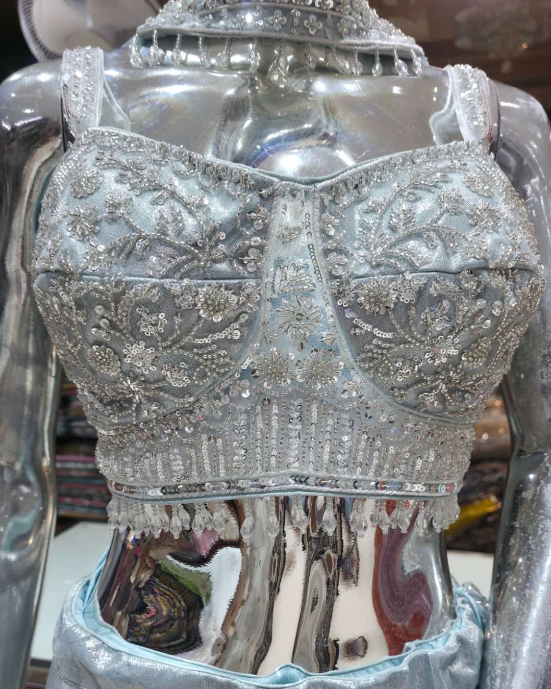 : Close-up of heavy sequin embroidery on ice blue blouse neckline