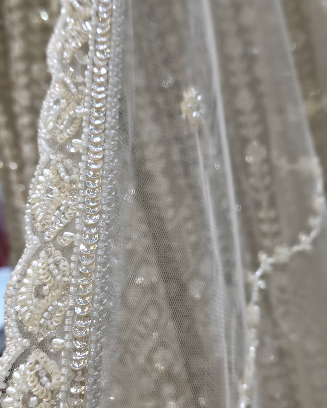 Detailed view of V-neck bodice on ivory front slit Anarkali gown with dense floral embroidery and fitted waist.
