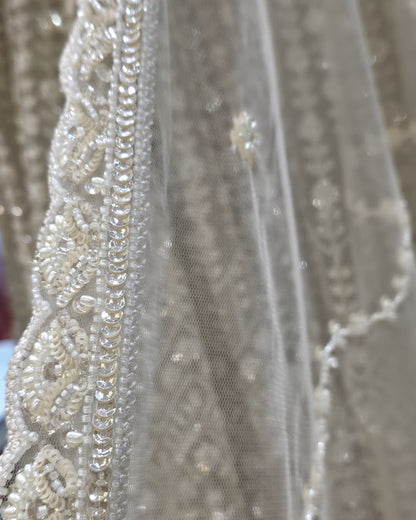 Detailed view of V-neck bodice on ivory front slit Anarkali gown with dense floral embroidery and fitted waist.