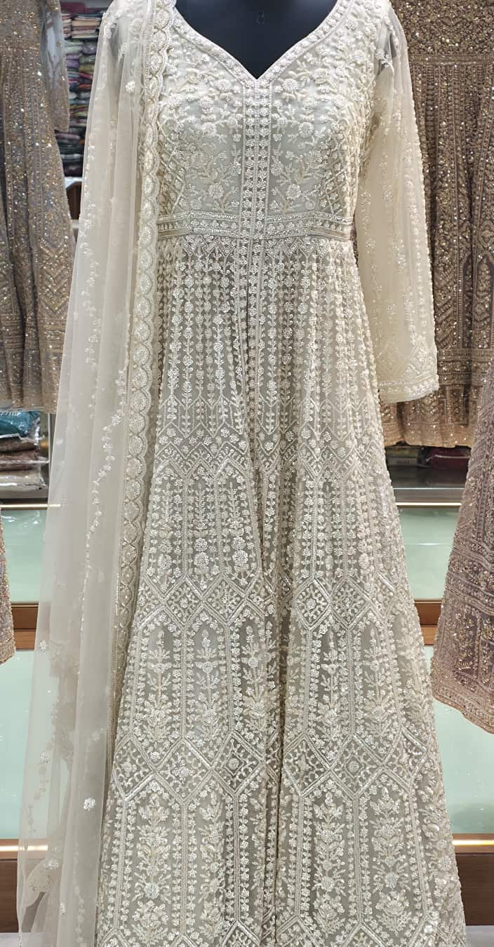 Ivory front cut Anarkali gown with heavy pearl and sequin embroidery, floor-length flared silhouette with net dupatta.
