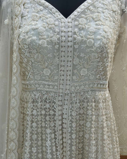 Detailed view of V-neck bodice on ivory front slit Anarkali gown with dense floral embroidery and fitted waist.