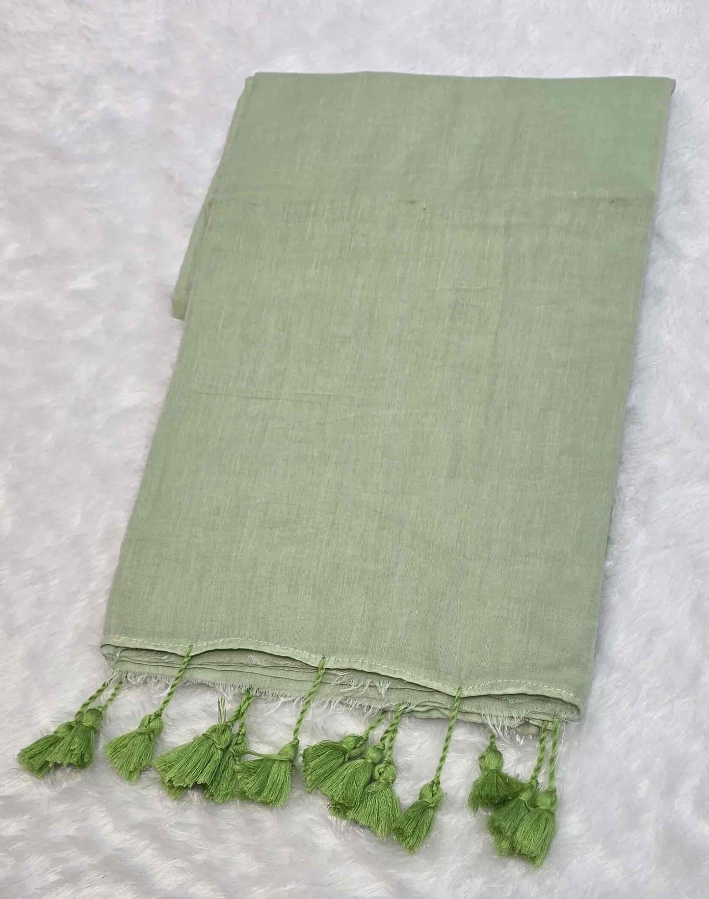Elegant light green mulmul cotton saree with hand-tied tassels