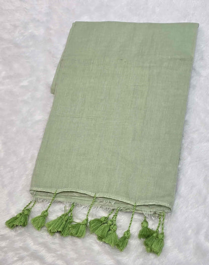 Elegant light green mulmul cotton saree with hand-tied tassels