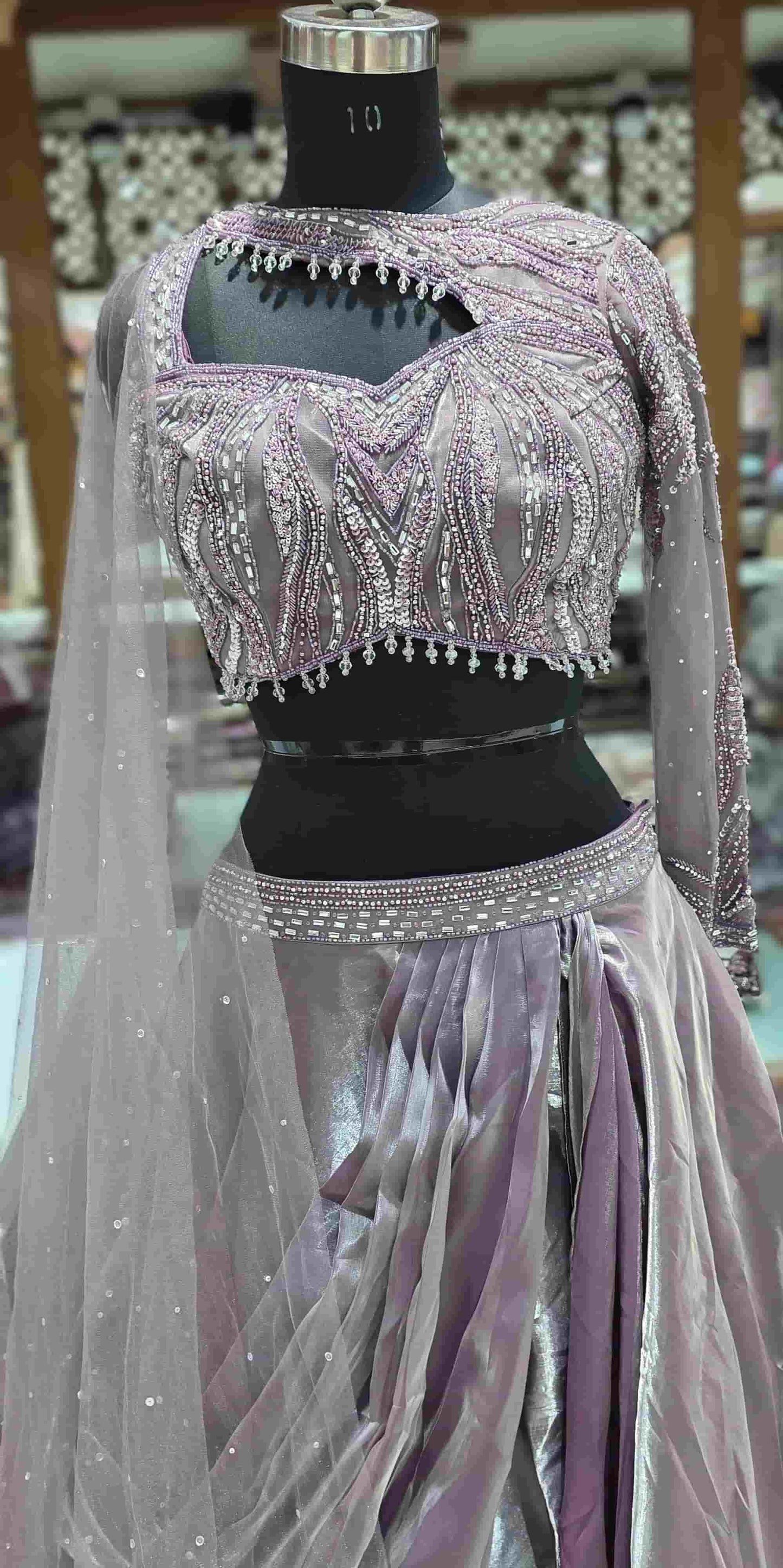 Close-up of dusky lilac blouse featuring crystal bead, sequin embroidery and asymmetrical neckline.