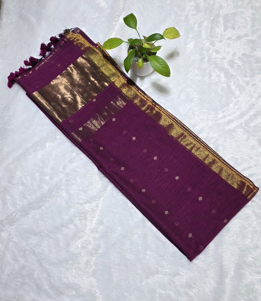 Pure magenta cotton saree with all-over copper butti work, copper zari pallu, and elegant golden border for festive ethnic wear.