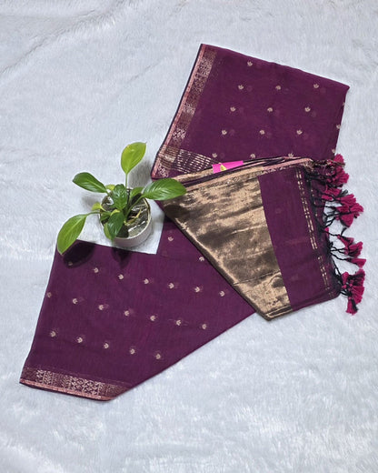 This magenta cotton saree with stylish butties detailing and copper zari pallu usually perfect for daily wear and family functions.