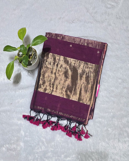 This magenta cotton saree with stylish butties detailing and copper zari pallu usually perfect for daily wear and family functions.