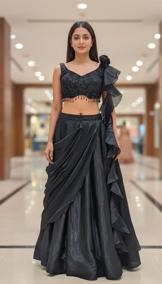 Front view of midnight black shimmer draped lehenga with embroidered V-neck blouse and bead tassel detailing
