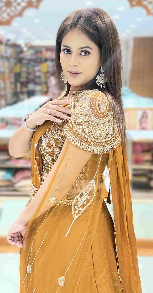 Close-up detail of heavily embroidered cape blouse with zari, sequins, beads, and stone work in mustard gold saree set.