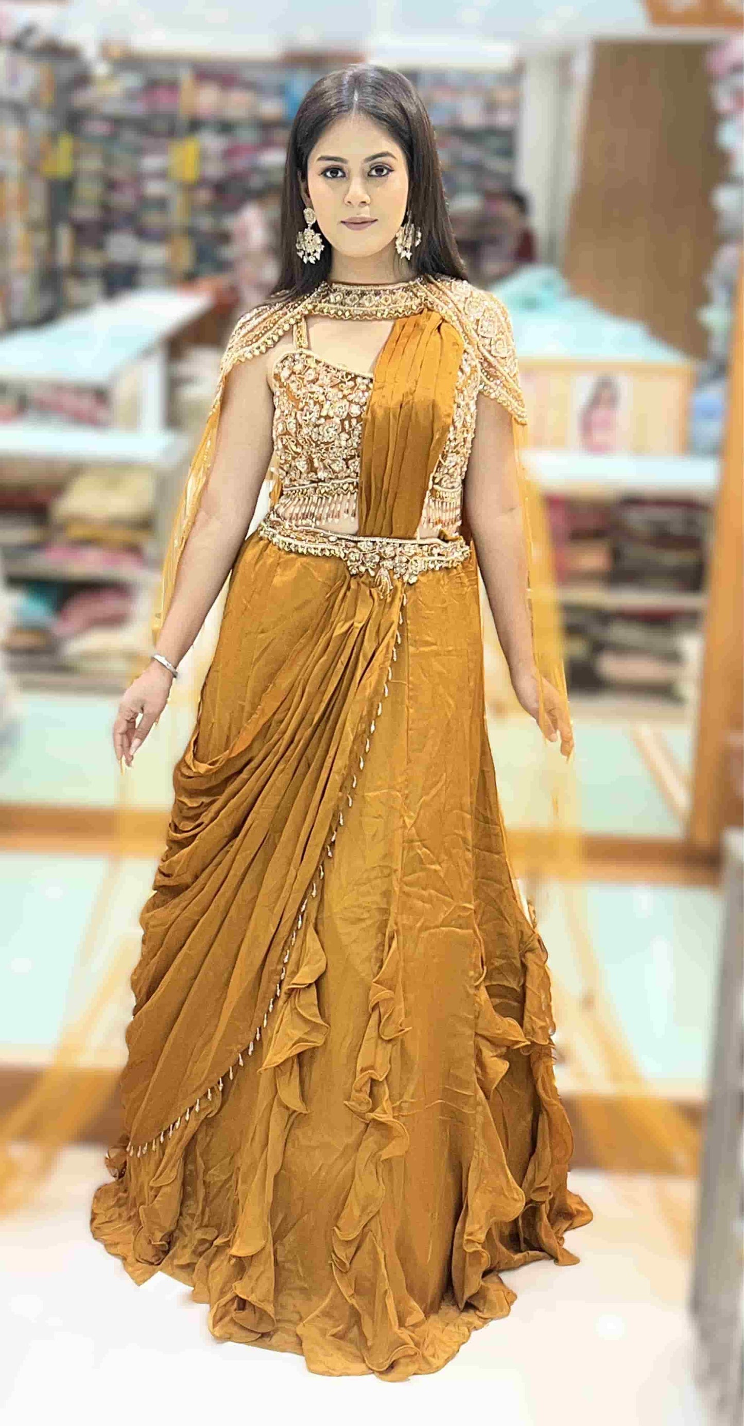 Mustard gold pre-draped ruffle saree with heavily embroidered cape blouse front view showcasing elegant drape and embroidery.