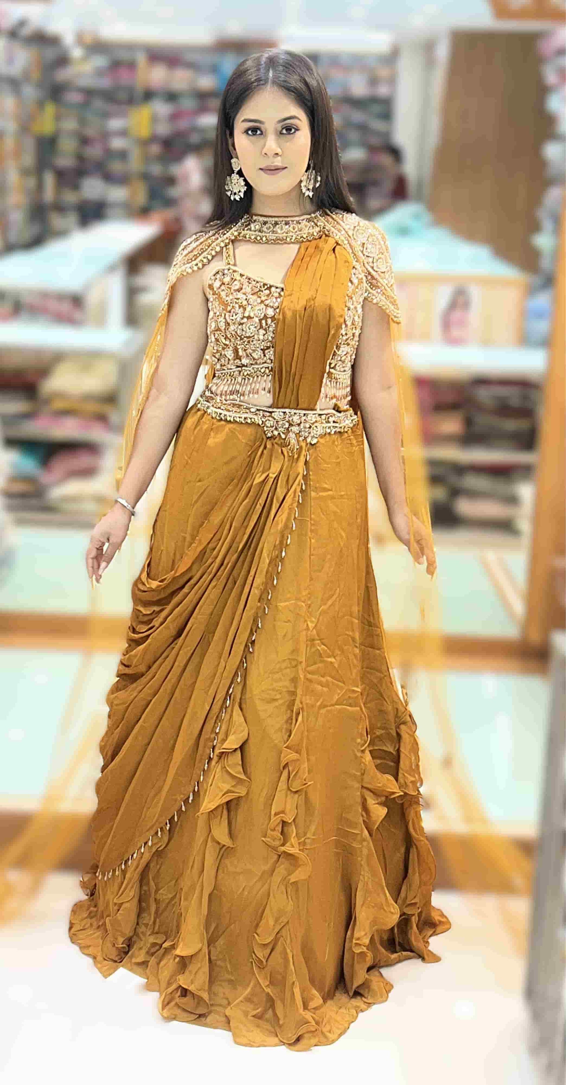 Mustard gold pre-draped ruffle saree with heavily embroidered cape blouse front view showcasing elegant drape and embroidery.