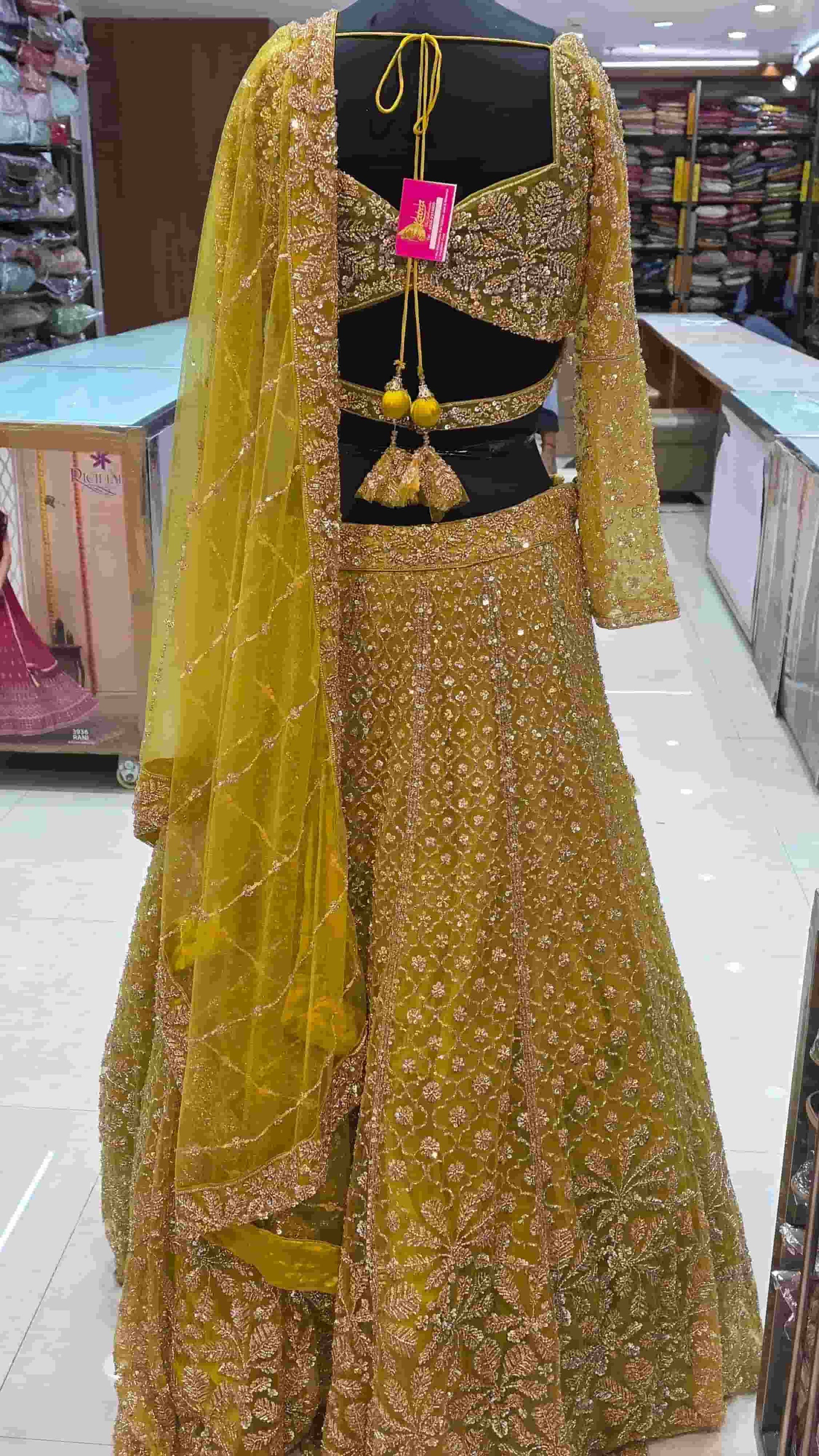 Close-up of mustard yellow blouse with V-neckline and intricate sequin embroidery.