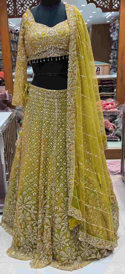 Mustard yellow embroidered lehenga set with heavy sequin work and net dupatta front view.