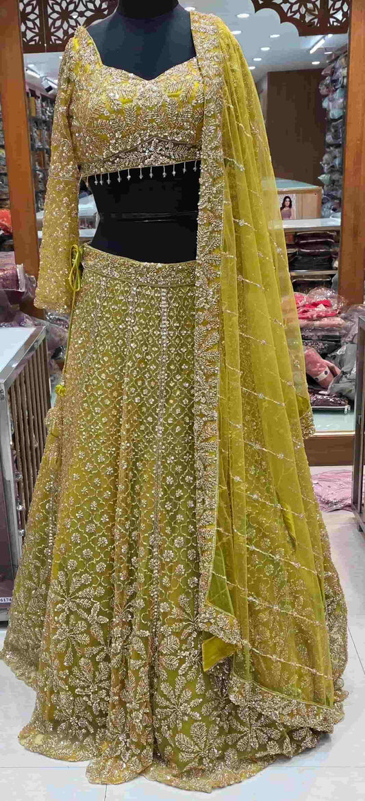 Mustard yellow embroidered lehenga set with heavy sequin work and net dupatta front view.
