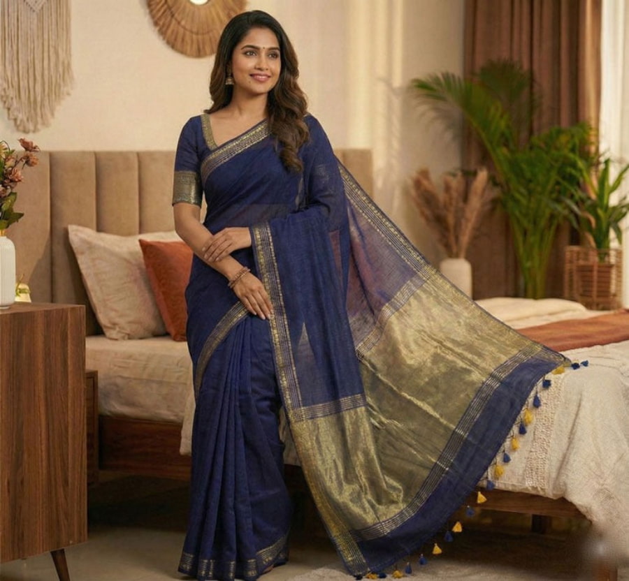 Navy blue pure cotton saree with all-over butties, copper zari pallu, simple golden border, and tassels.