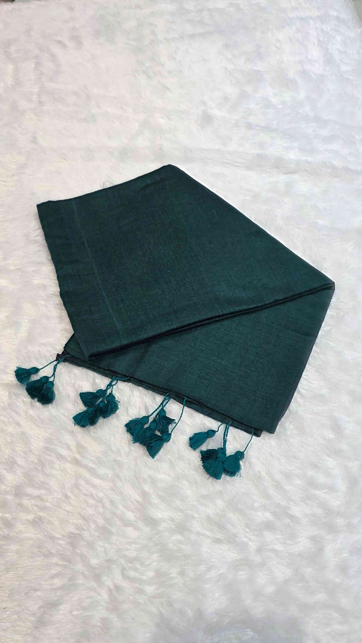 Lightweight mulmul cotton saree in dark teal green with hand-tied tassels