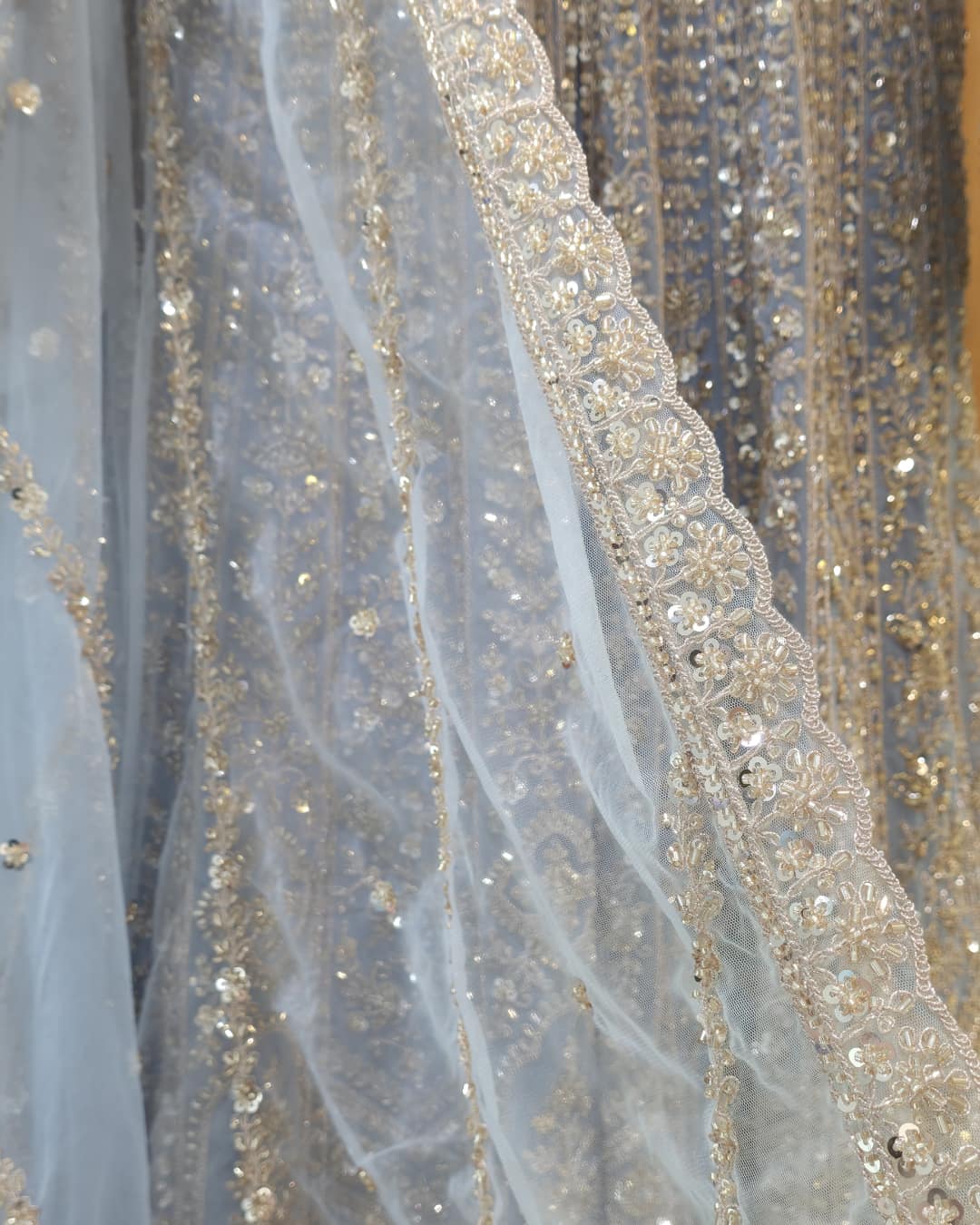 Full-length sheer net sleeve with delicate embroidery on powder blue front slit Anarkali dress.