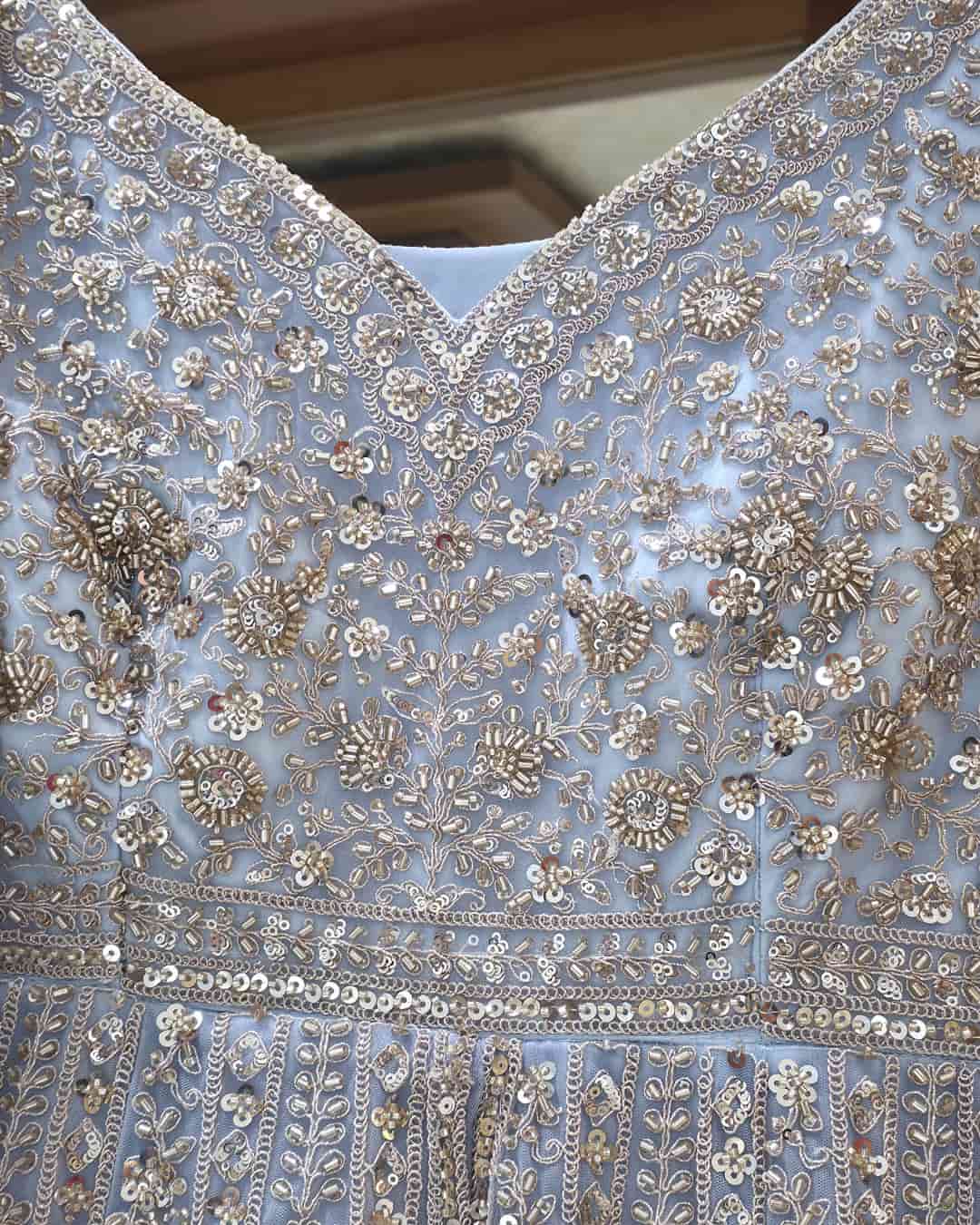 Close-up of V-neck bodice on powder blue embroidered Anarkali featuring intricate bead and zari detailing.