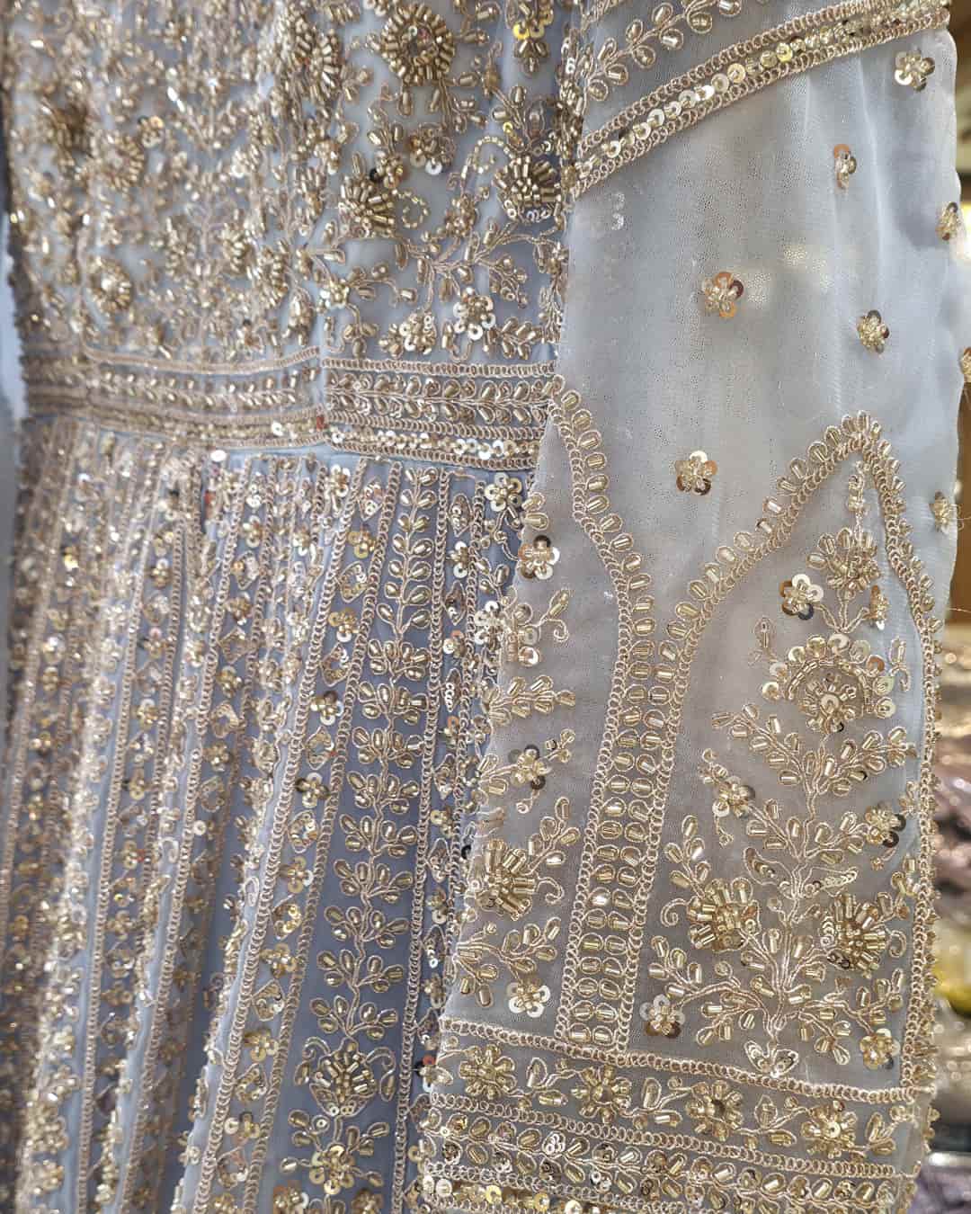 Powder blue net dupatta with scalloped embroidered border paired with front cut Anarkali gown.