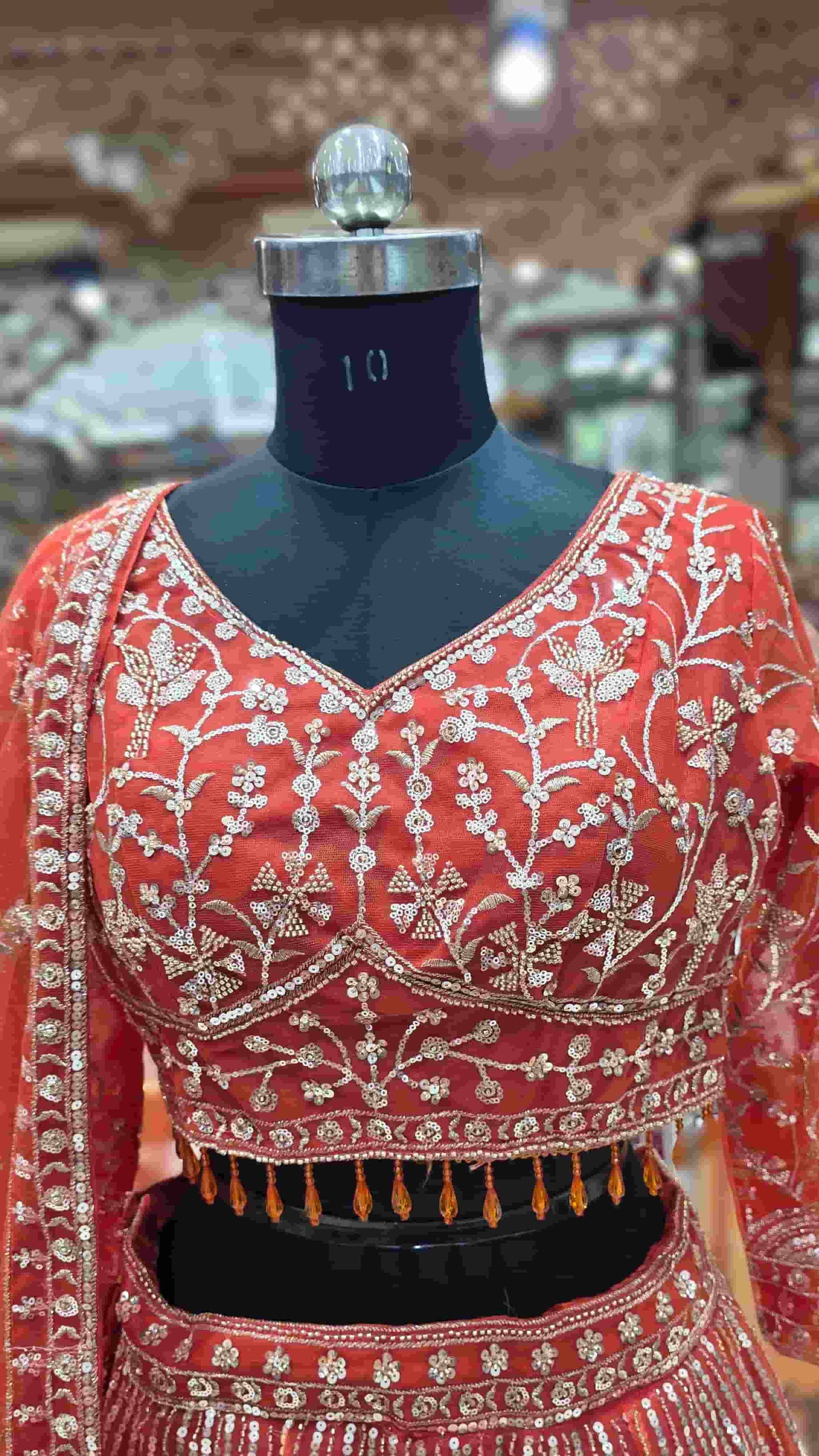 Designer rust orange bridal lehenga set with detailed embroidery and net dupatta.