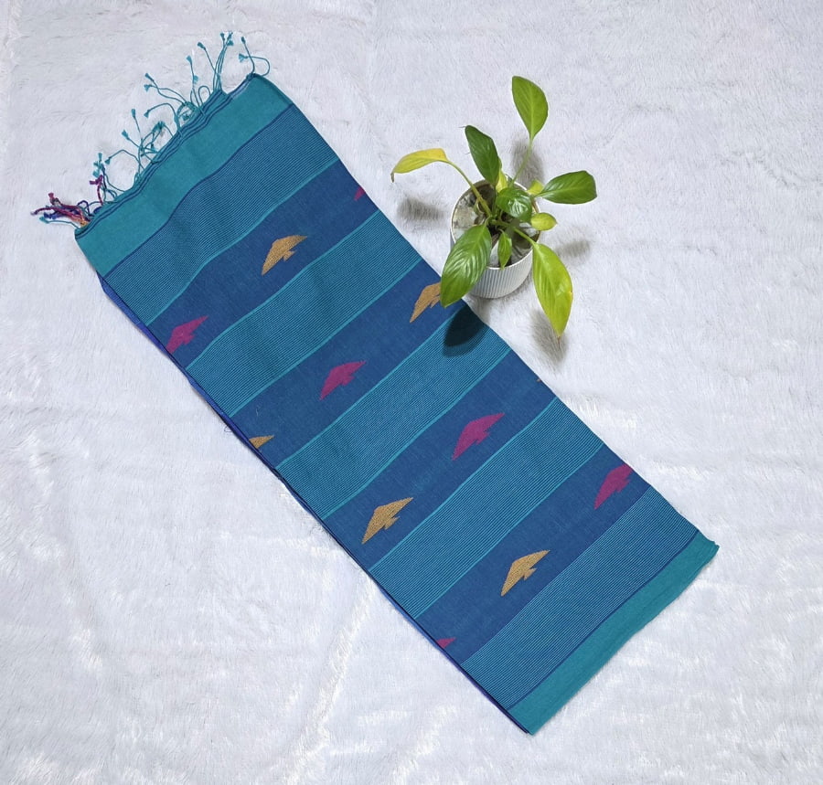 Sky blue cotton saree featuring small triangle butties, Ikat woven border, contrast pallu styling and tassel detailing. Perfect for office wear and daily wear.
