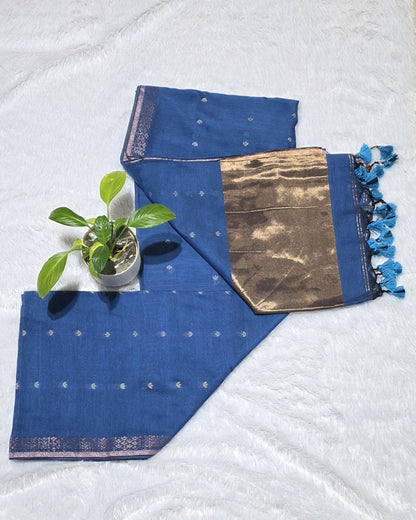 THis is stylish teal blue cotton saree with subtle butti deataling and contrast cpper zari pallu with elegant tessels at its border specially for casual outings and office wear.