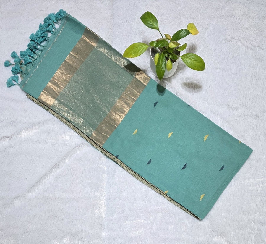 Teal green cotton saree with overall colourful triangle butties, copper zari pallu highlights and subtle golden border with tassels

